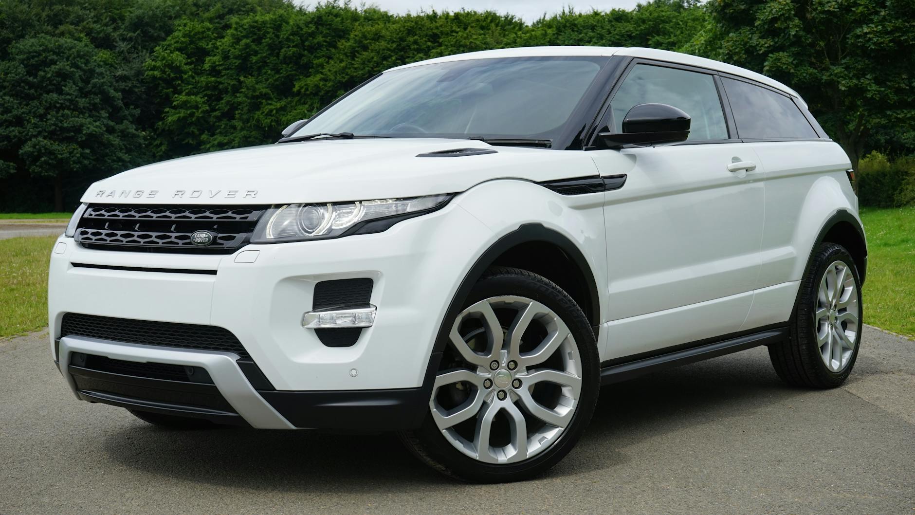 Biały Range Rover zaparkowany przy zielonej drodze Biały Range Rover zaparkowany przy zielonej drodze