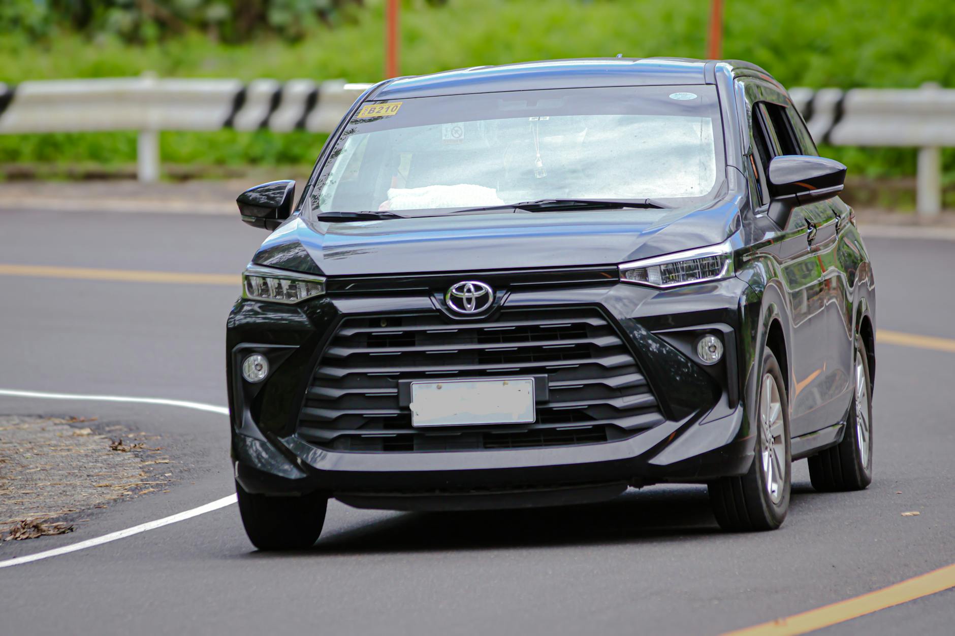 Czarny minivan Citroën jedzie po miejskiej ulicy za dnia