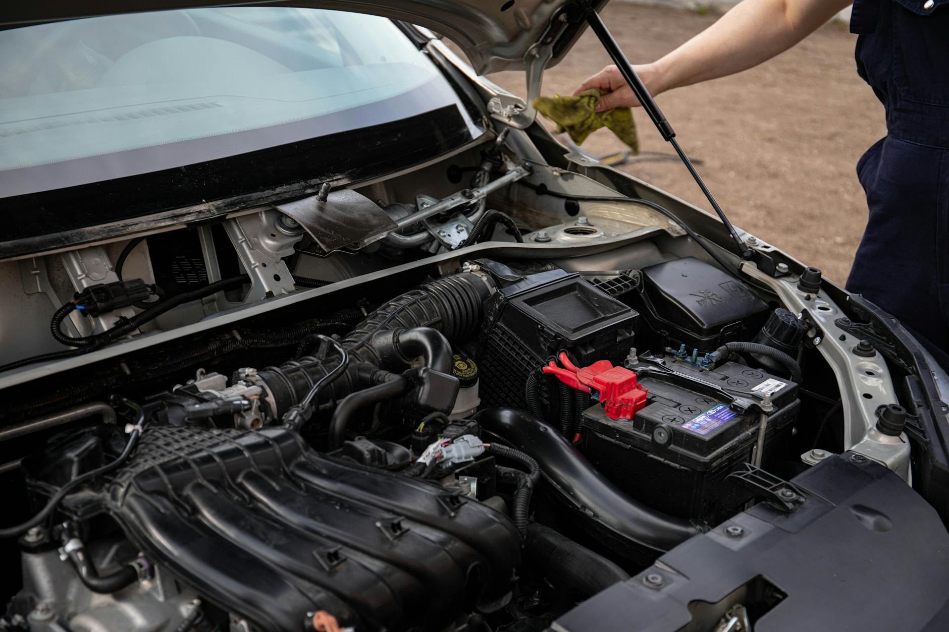 Mechanik sprawdza komorę silnika Cadillaca podczas przeglądu