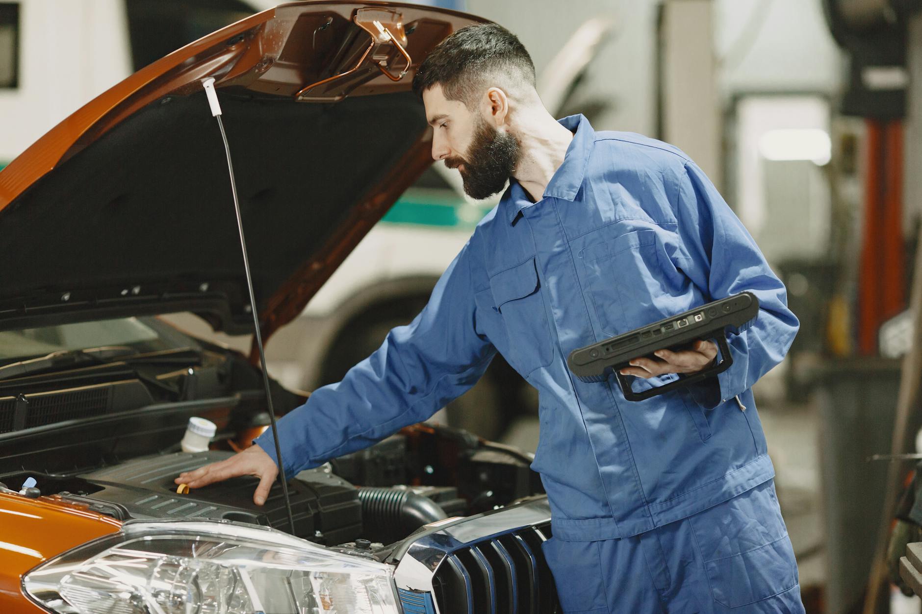 Mechanik w garażu sprawdza silnik Cadillaca przy otwartej maskie