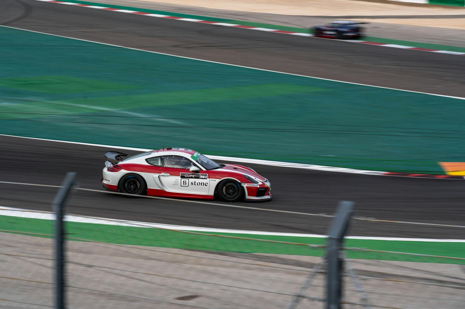 Czerwony samochód wyścigowy Ferrari pędzący po torze motorsportowym