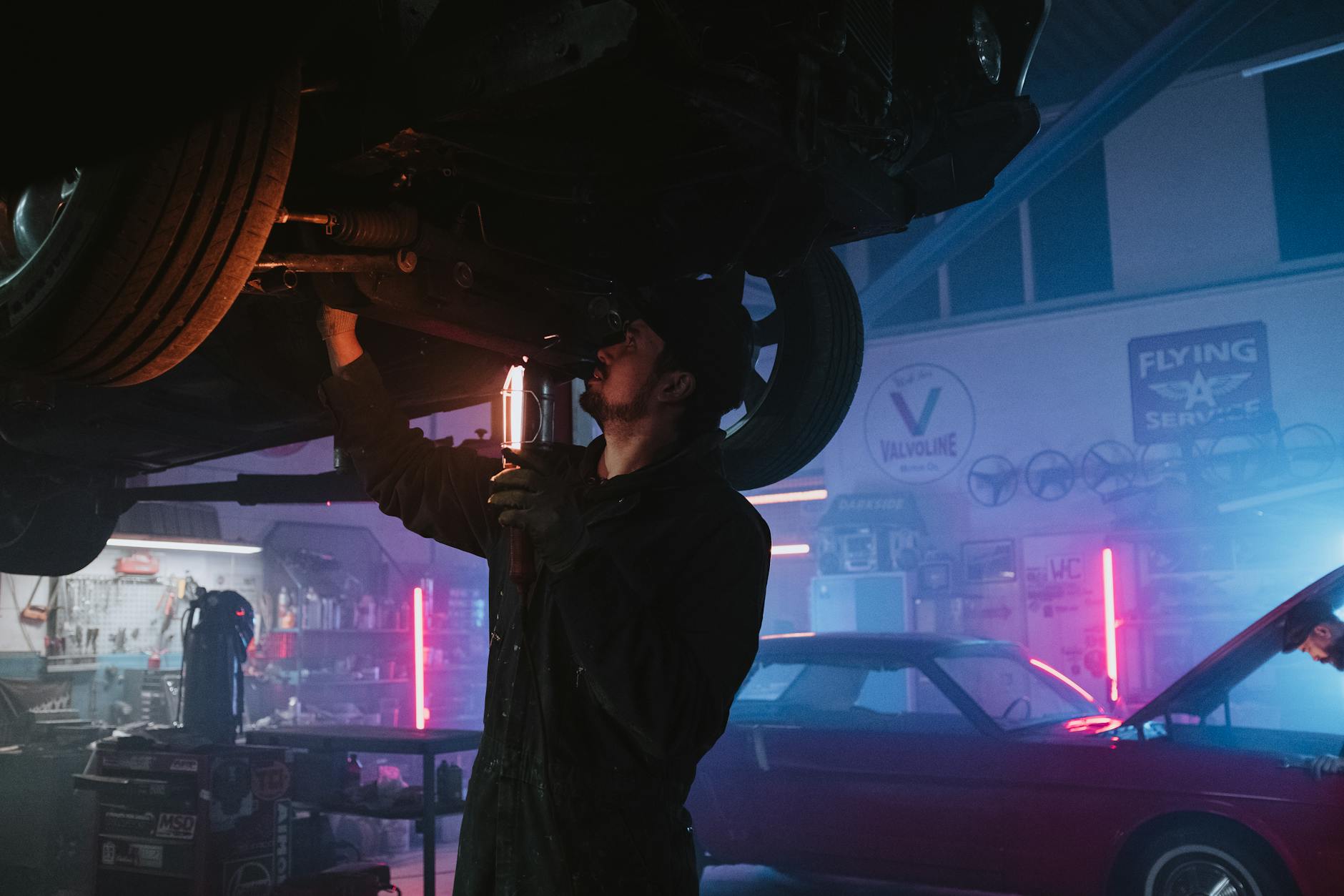 Mechanik sprawdza podwozie samochodu BYD w jasno oświetlonym warsztacie