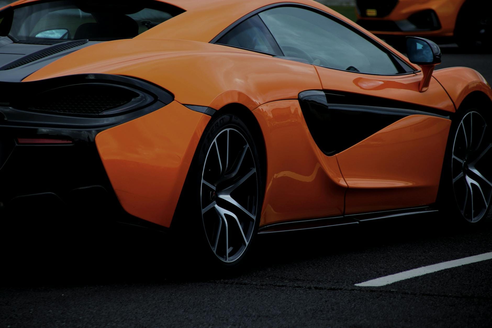 Pomarańczowy Aston Martin DB9 jedzie drogą w Anglii