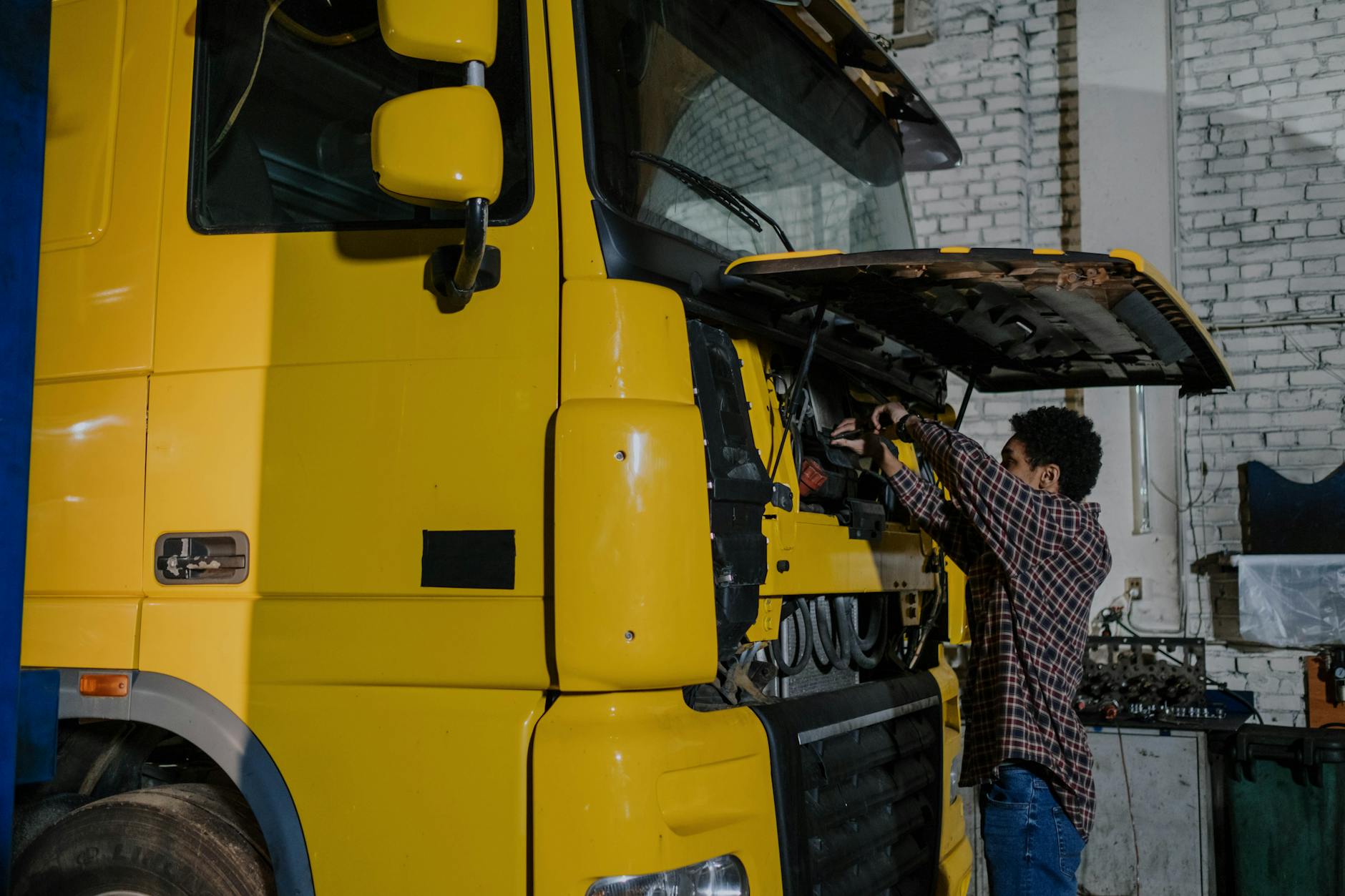 Mechanik pracuje przy silniku ciężarówki w warsztacie Mercedes-Benz