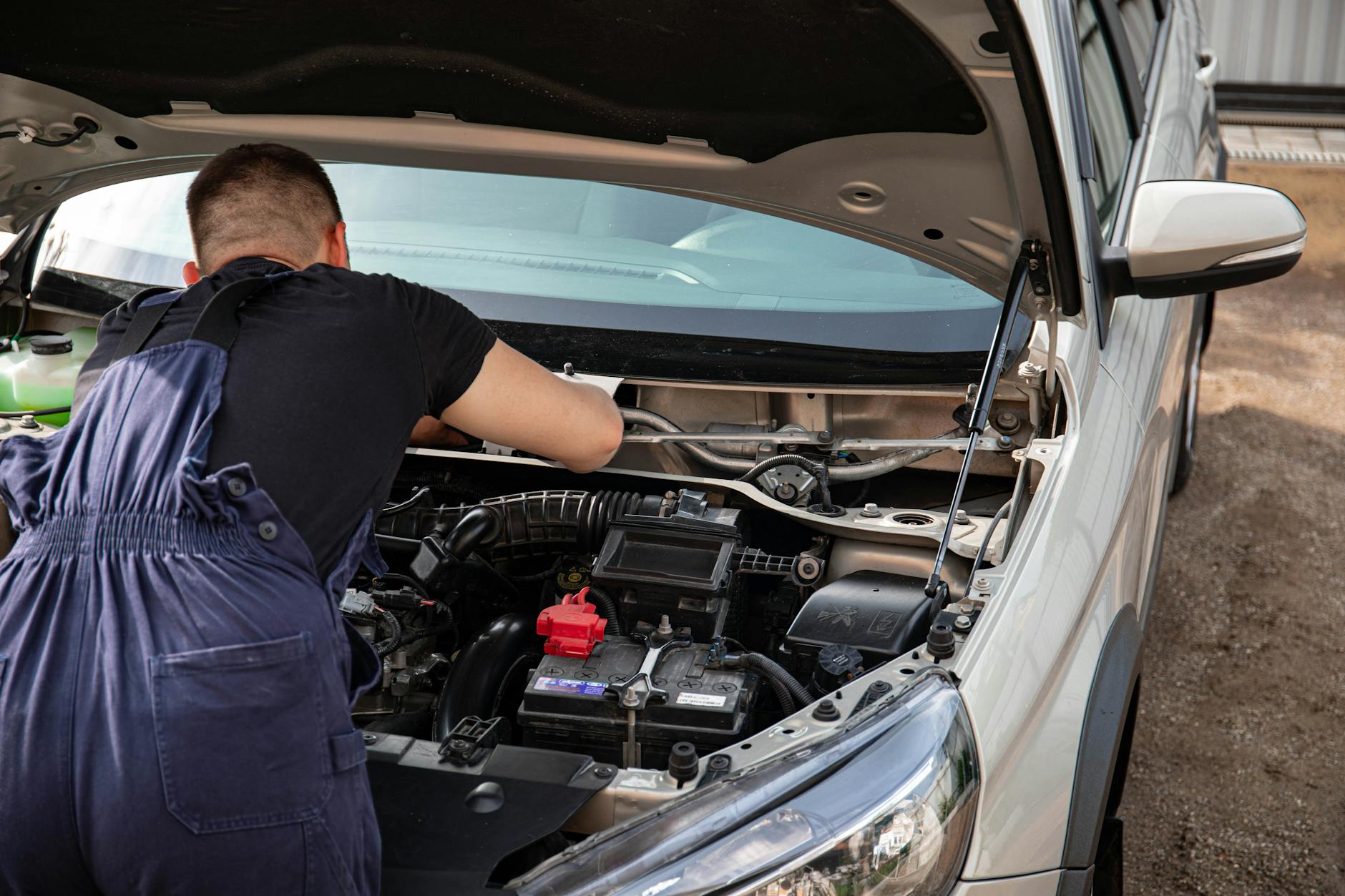 Mechanik przy silniku Mercedesa podczas naprawy na zewnątrz