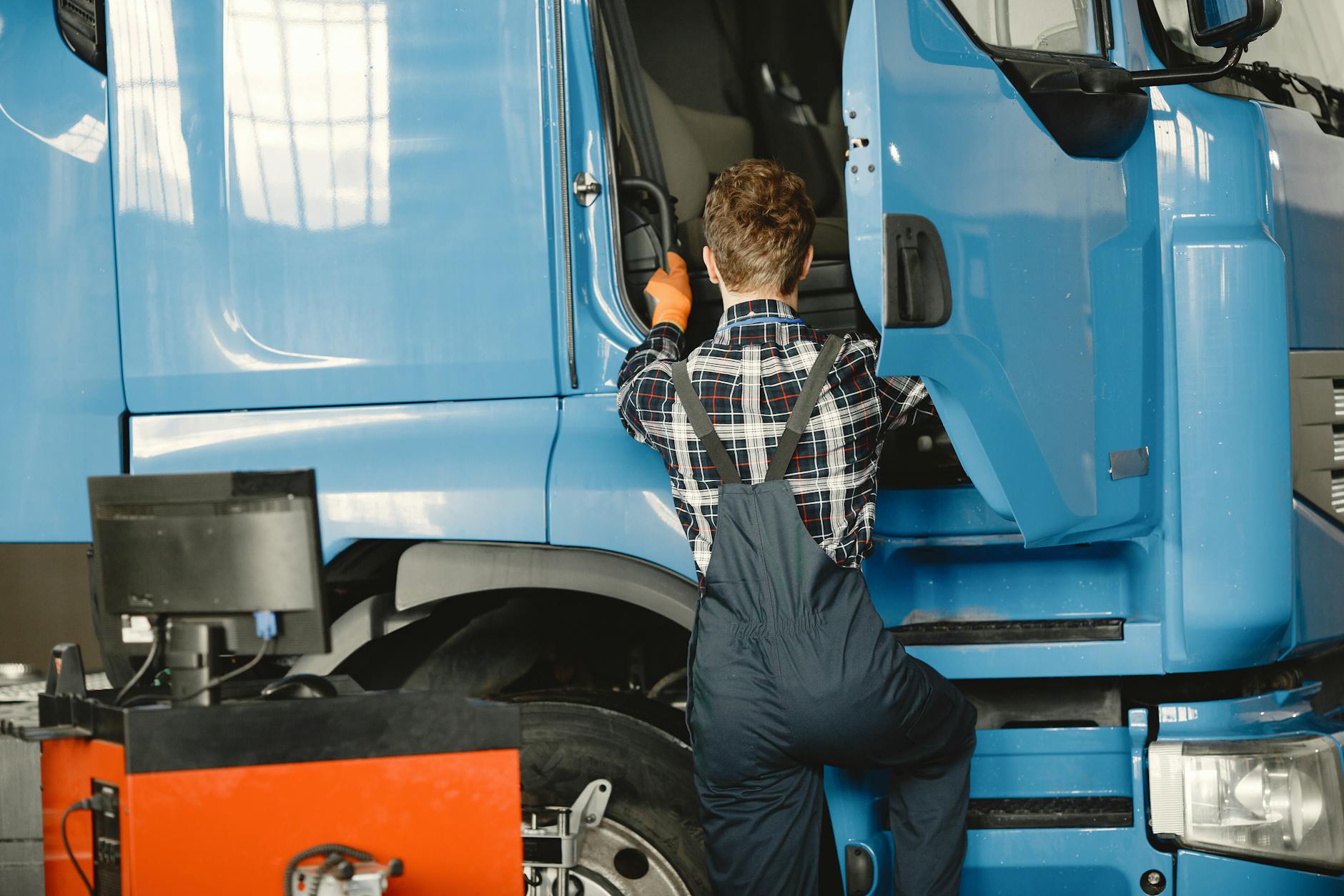 Mechanik w warsztacie sprawdza ciężarowego Mercedesa od tyłu