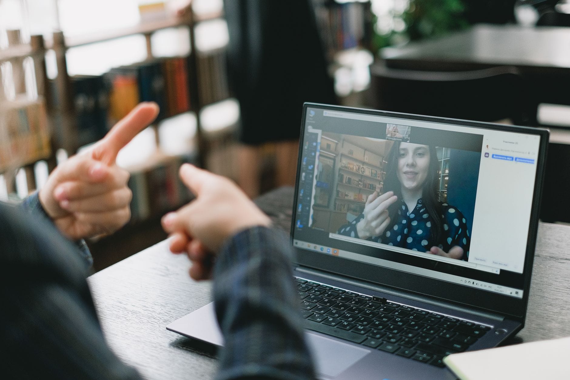 Nauczycielka języka migowego uczy online przez laptop w jasnym biurze Nauczycielka języka migowego uczy online przez laptop w jasnym biurze